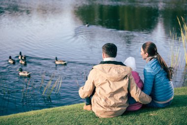 Family looking at lake with ducks clipart