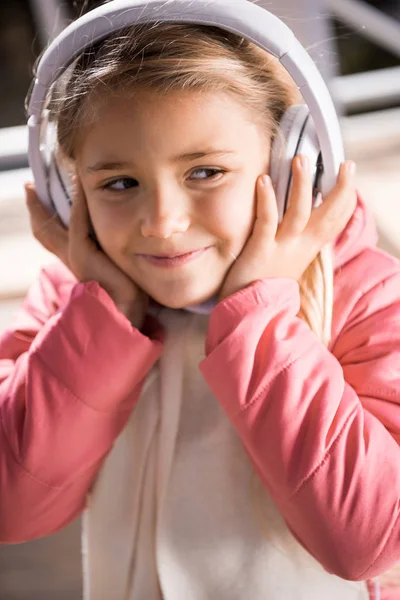 Sorrindo menina em fones de ouvido brancos — Fotografia de Stock