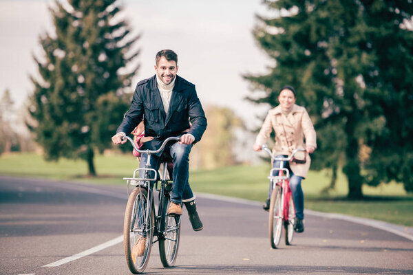 Happy family riding bicycles in park