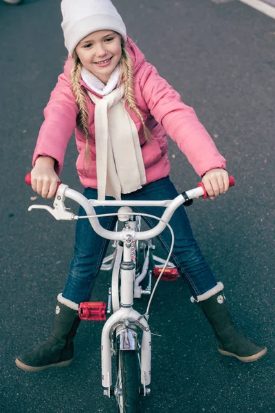 Urocza dziewczyna uśmiechający się siedząc na rowerze — Zdjęcie stockowe