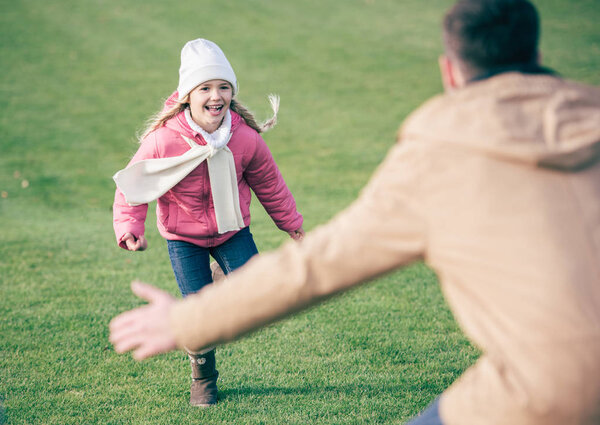 Adorable smiling girl running to father 