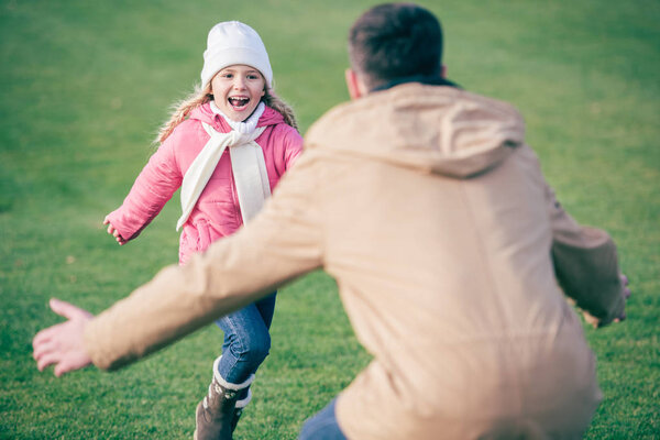 Adorable smiling girl running to father 