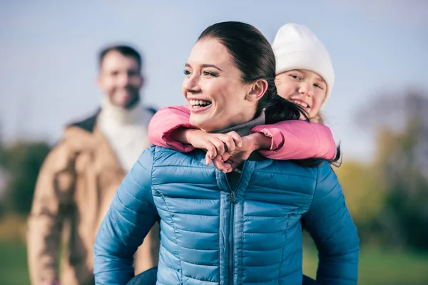 Küçük kızı piggybacking neşeli anne — Stok fotoğraf