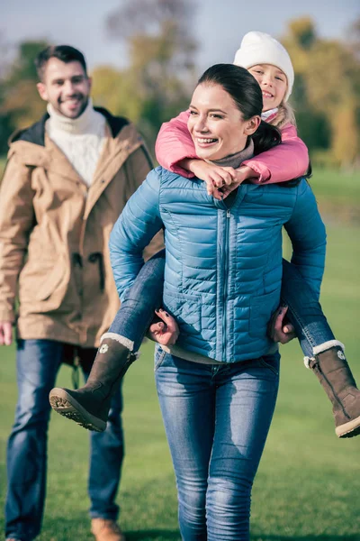 Cheerful mother piggybacking little daughter — Stock Photo, Image