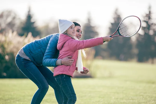 Sorridente madre con figlia giocare badminton — Foto Stock