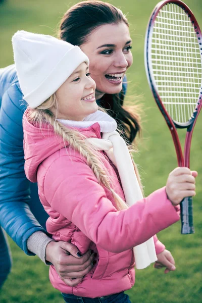 Sorrindo mãe com a filha jogando badminton — Fotografia de Stock