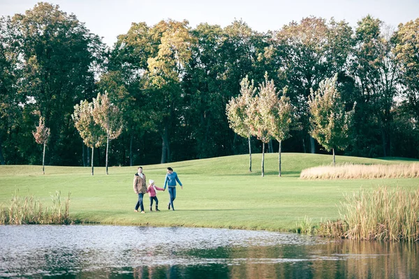 Happy family walking near lake — Stock Image Happy family walking near lake Royalty Free Stock Photos