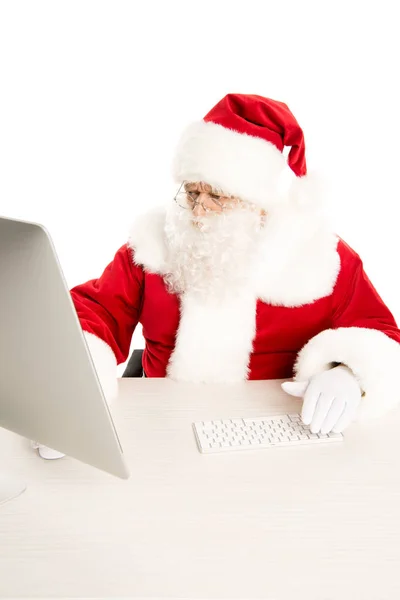 Santa Claus looking at computer — Free Stock Photo