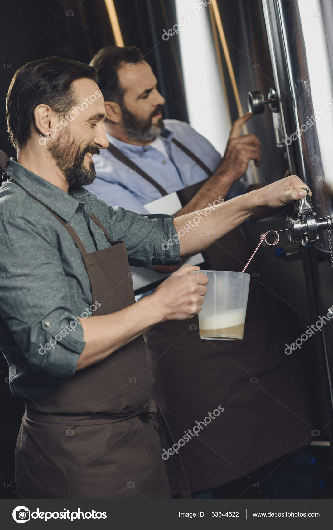 Brewery worker pouring beer Stock Photo by ©ArturVerkhovetskiy 133344522
