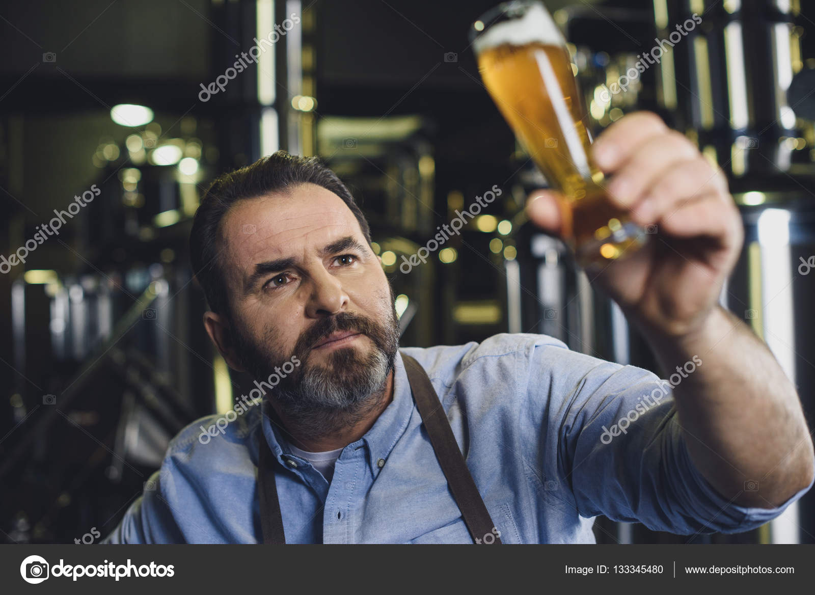 Brewery worker with glass of beer — Stock Photo © ArturVerkhovetskiy