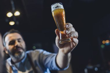 Brewery worker with glass of beer clipart