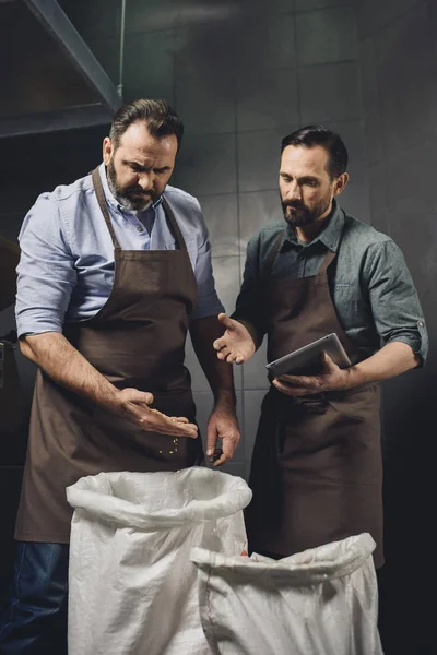 Brewery workers inspecting grains — Stock Photo, Image