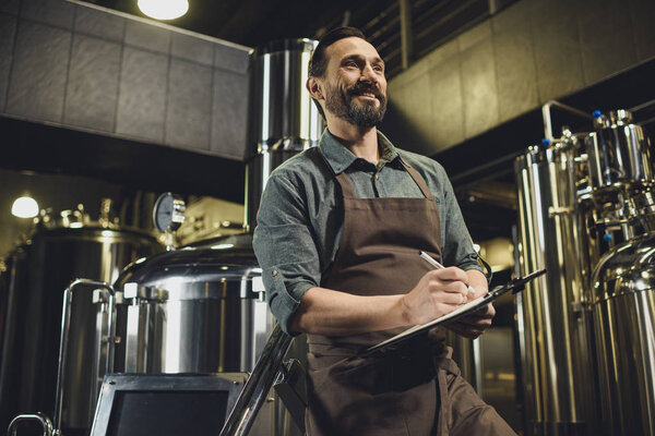 Worker inspecting equipment at brewery