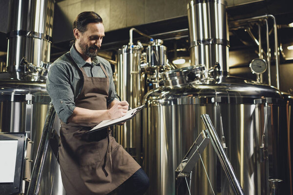 Worker inspecting equipment at brewery