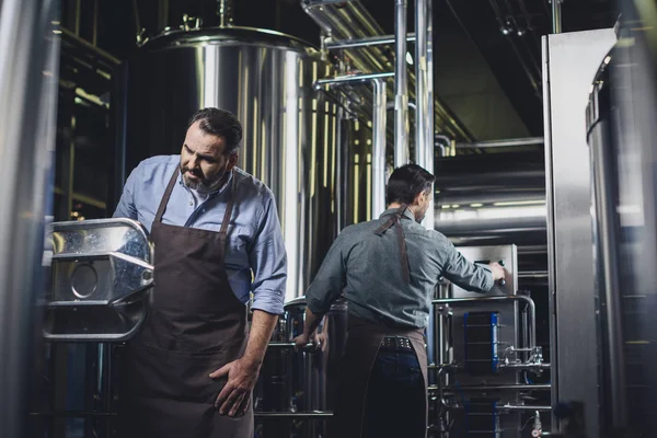 Brewers working with industrial equipment — Stock Photo, Image