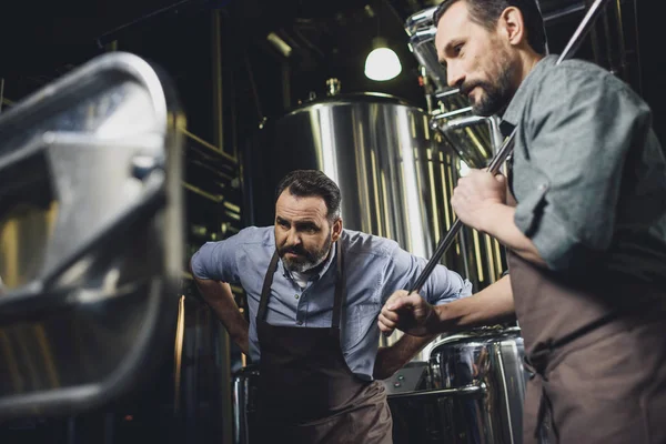 Brewers working with industrial equipment — Stock Photo, Image