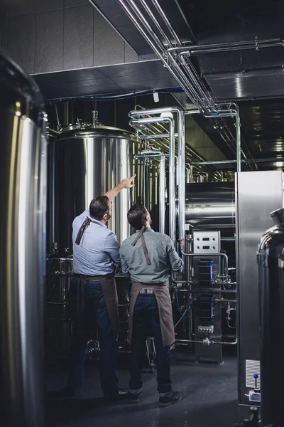 Пивовары, работающие с промышленным оборудованием — стоковое фото