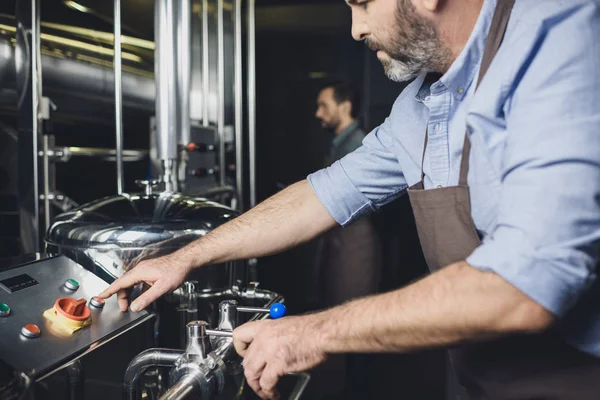 Brewer working with industrial equipment — Stock Photo, Image