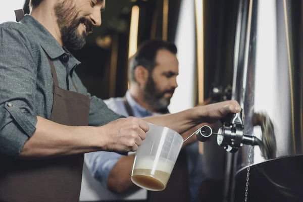 Brouwerij werknemer gieten bier — Stockfoto