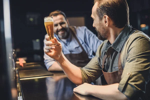 Brewery worker with glass of beer — Stock Photo, Image