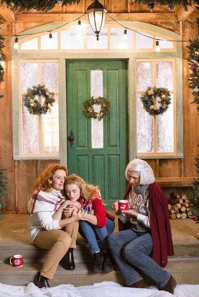 Family drinking hot tea on stairs