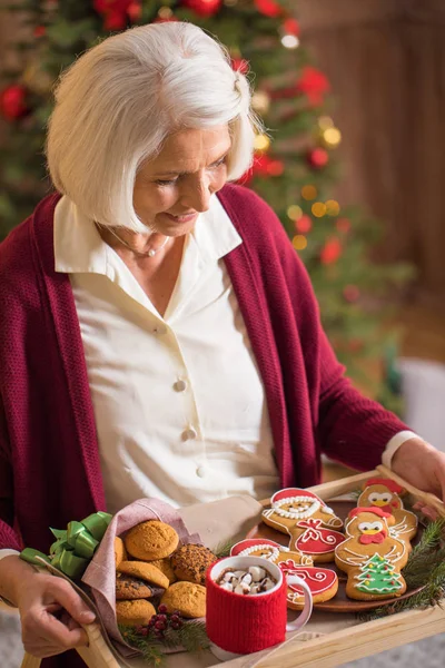 クリスマスのクッキーとトレイを保持している女性  — 無料ストックフォト