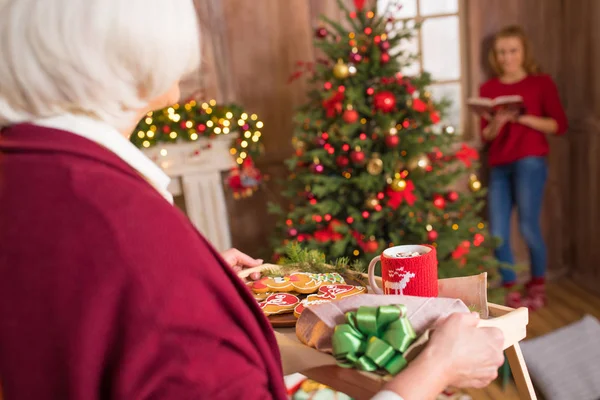 クリスマスのクッキーとトレイを保持している女性  — 無料ストックフォト