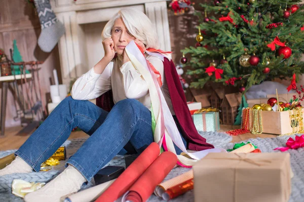 Mujer mayor reflexiva con cajas de regalo —  Fotos de Stock