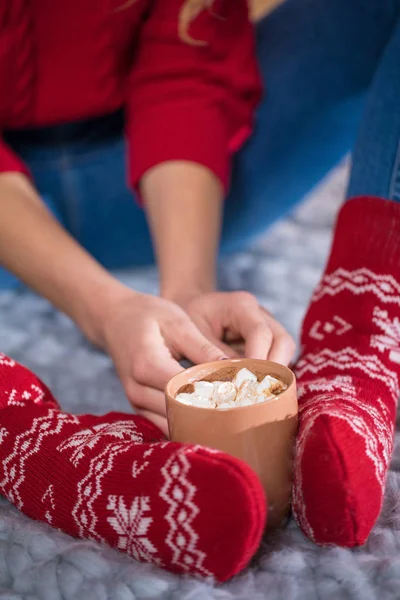 Pés femininos e xícara com chocolate quente — Fotografia de Stock Grátis