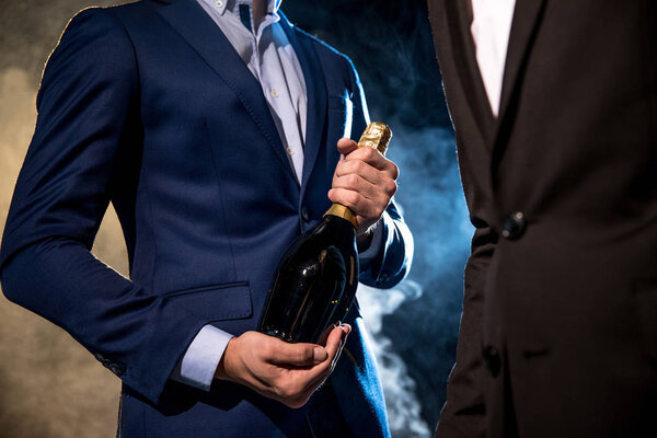 Stylish men with champagne bottle