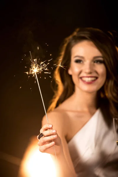 Beautiful woman holding sparkler — Stock Photo, Image