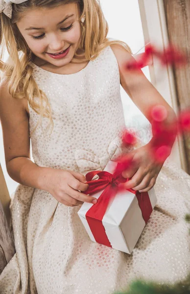 Flickan öppnar presentförpackning — Stockfoto