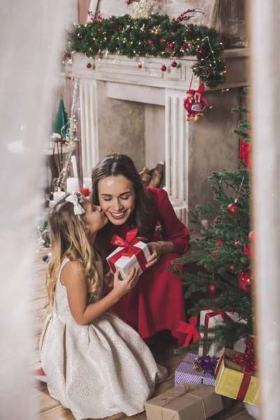 Mor som gir datter julegave – stockfoto