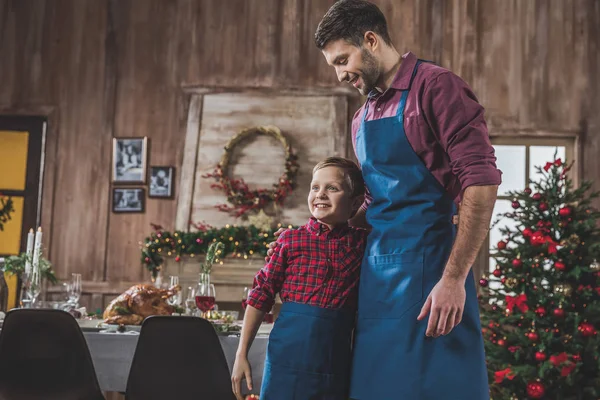 Pai e filho em aventais azuis — Fotografia de Stock