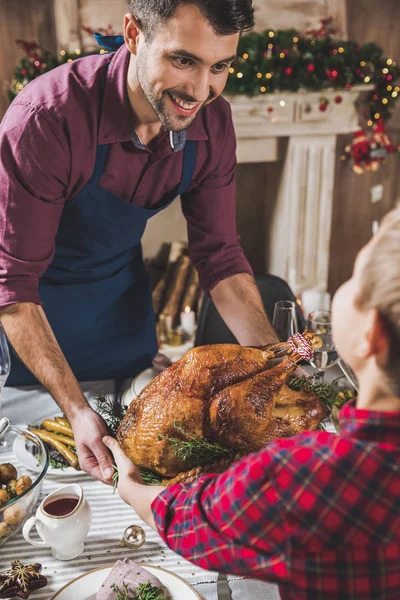 Father and son holding roasted turkey — Stock Photo, Image