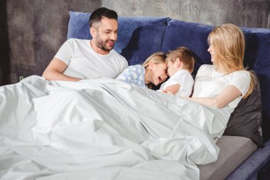 Mutlu aile yatakta.    