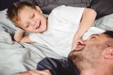 Mutlu baba ve oğul yatakta  