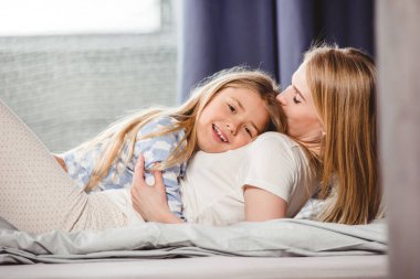 mutlu anne ve kızı yatakta 