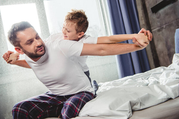 Happy father and son on bed 