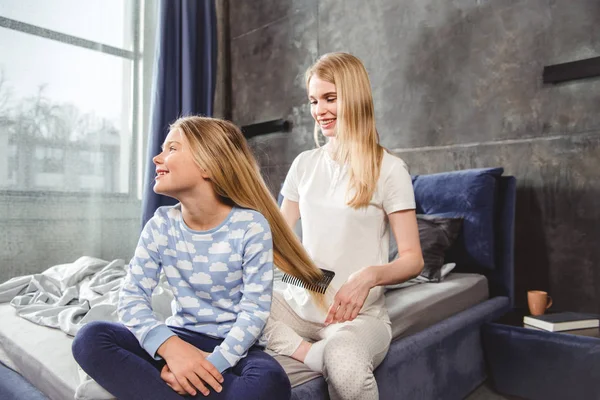 Mother combing hair of daughter — Stock Photo, Image