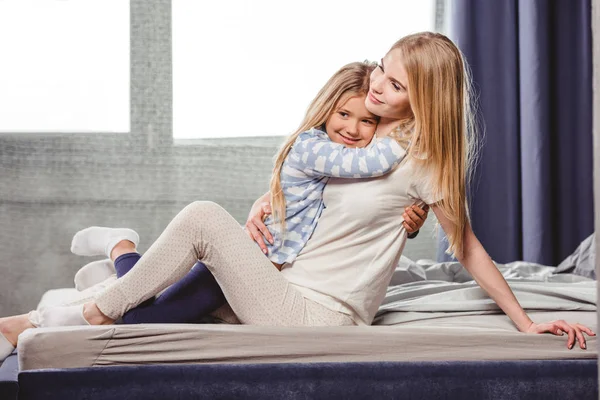 Lycklig mor och dotter i sängen — Stockfoto