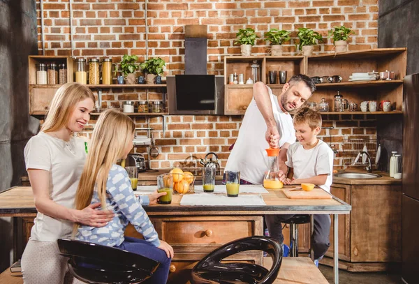 Familie stellt Orangensaft her — Stockfoto