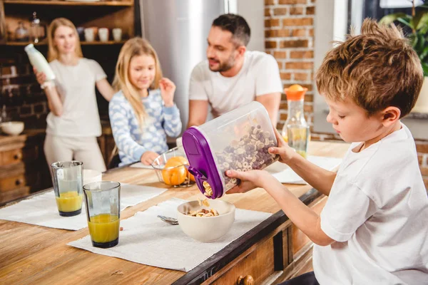 Jongen giet corn flake ringen — Stockfoto