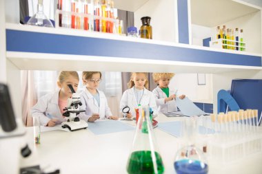Schoolchildren studying in laboratory    clipart