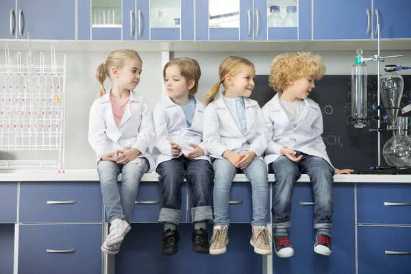 Crianças em idade escolar sentadas em laboratório — Fotografia de Stock