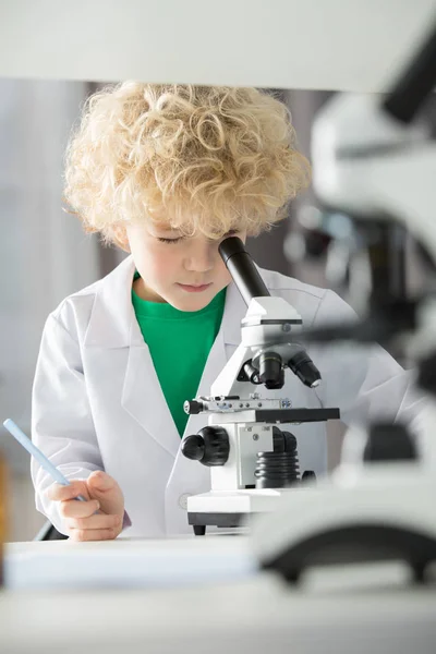 Schoolboy using microscope — Stock Photo, Image
