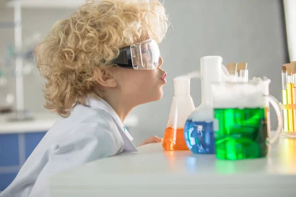 Schoolboy looking at flasks — Stock Photo, Image