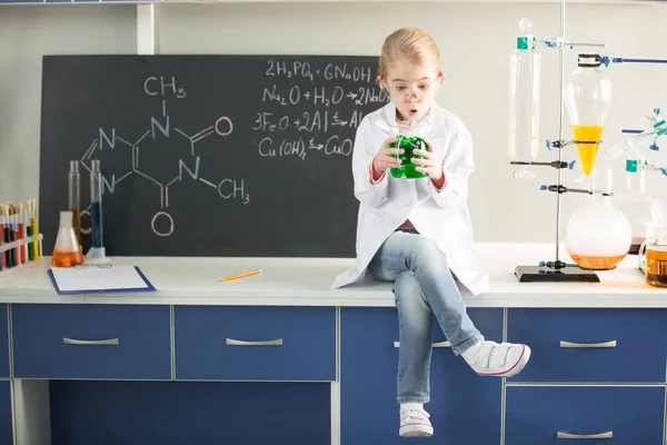 Schoolgirl holding flask with sample — Stock Photo, Image