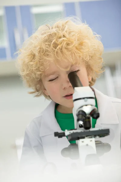 Junge schaut durchs Mikroskop — Stockfoto