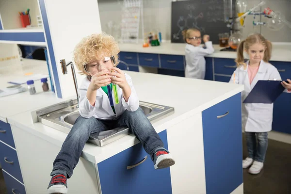 Jongen zit in gootsteen — Stockfoto